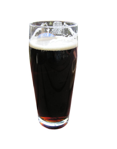 a pint glass filled with a dark stout